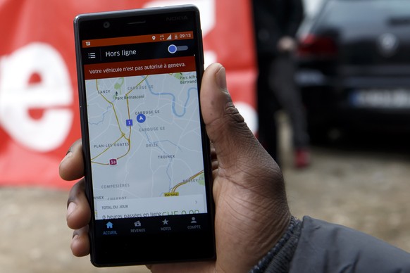 ARCHIVBILD ZUR MK DER UNIA ZUM THEMA PLATTFORM-ARBEIT --- Un chauffeur Uber en greve montre que sont application Uber est mise hors connexion, lors d&#039;une manifestation devant le siege genevois d& ...