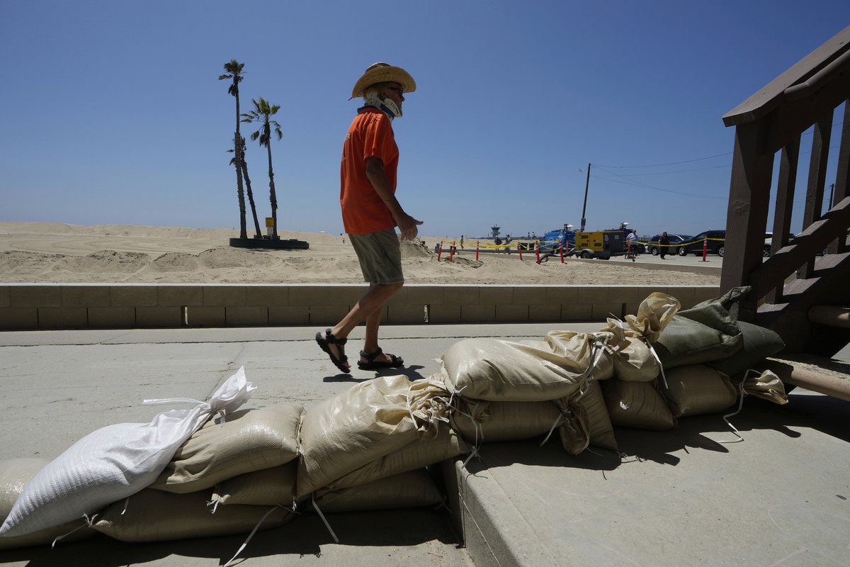 Seal Beach resident Tom Ostrom, walks past a home protected with sandbags in Seal Beach, Calif., Friday, Aug. 18, 2023. Hurricane Hilary is churning off Mexico's Pacific coast as a powerful Categ ...