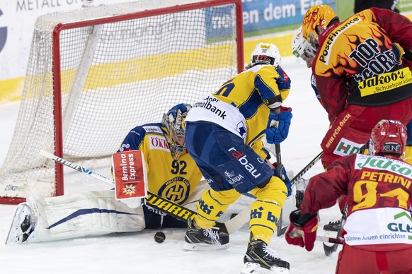 Tigers Topscorer Ben Maxwell, rechts, kaempft um den Puck gegen Davos&#039; Goalie Robert Mayer, und Sven Jung, Mitte, waehrend dem Meisterschaftsspiel der National League zwischen den SCL Tigers und  ...