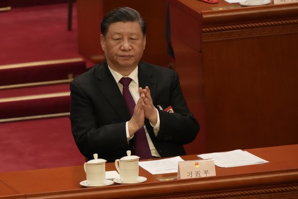 Chinese President Xi Jinping applauds during a session of the Chinese National People's Congress (NPC) at the Great Hall of the People in Beijing, Friday, March 10, 2023. (AP Photo/Mark Schiefelbein)