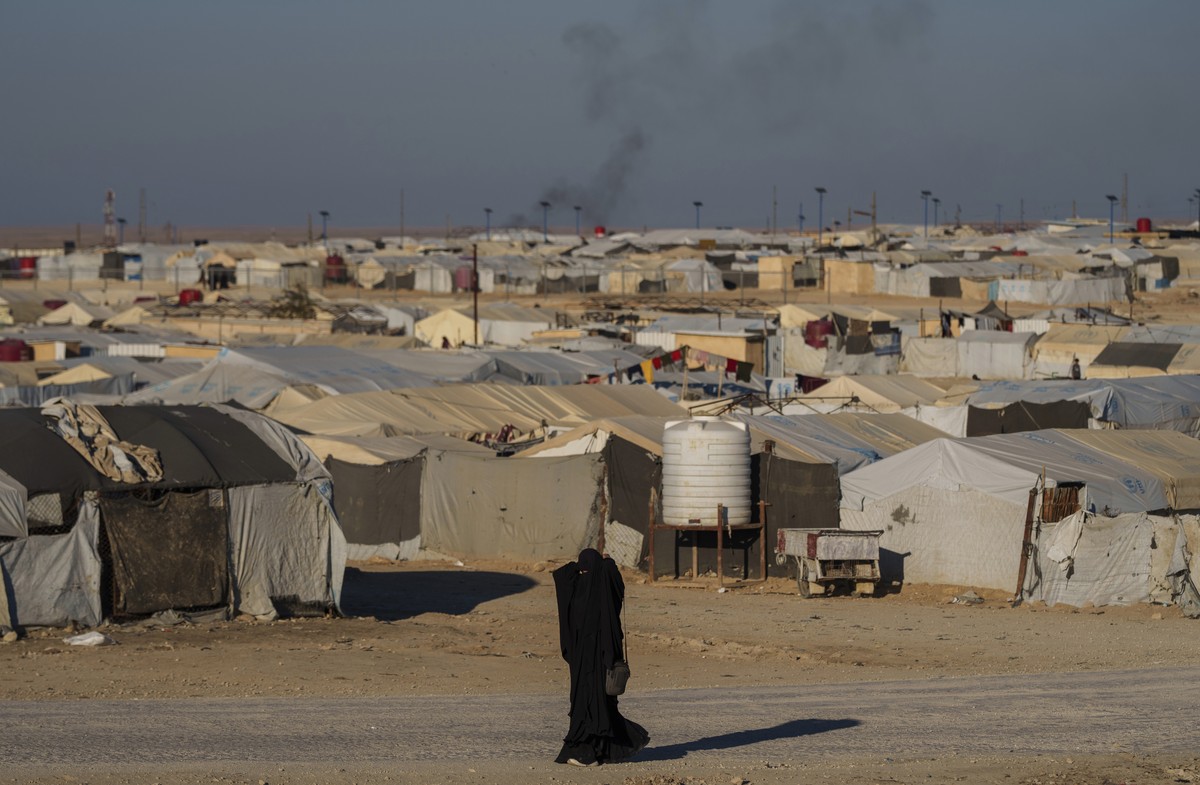 FILE - A woman walks in the al-Hol camp in northeastern Syria's Hasakeh province, where tens of thousands of mostly women and children linked to the Islamic State group have been living for years ...