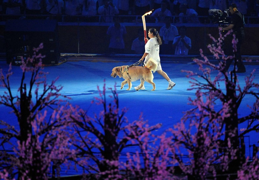 (190411) -- BEIJING, April 11, 2019 (Xinhua) -- File photo taken on Sept. 6, 2008 shows Torchbearer Ping Yali, the first Chinese Paralympic gold medalist in 1984, relays with a guide dog during the op ...