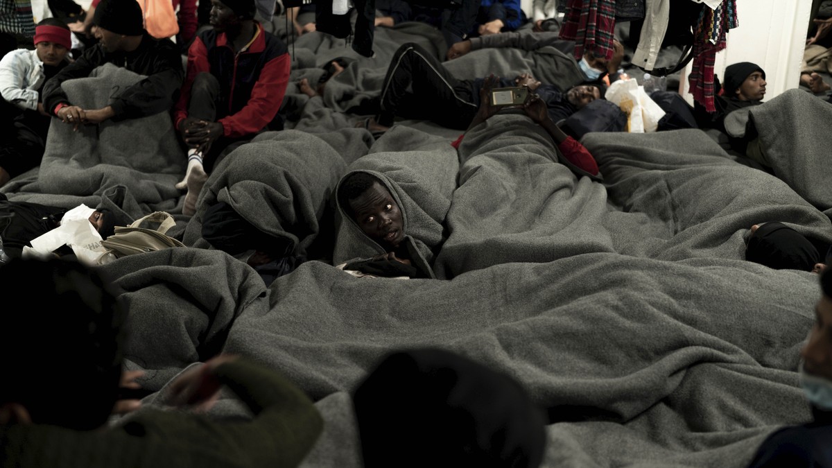 Migrants are wrapped with blankets as they gather on the deck of the Ocean Viking rescue ship, in the Strait of Sicily, in the Mediterranean Sea, Friday, Nov. 4, 2022. (AP Photo/Vincenzo Circosta)