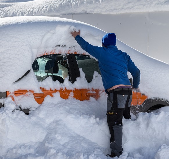 Ein Arbeiter befreit sein Auto vom Schnee, am Donnerstag, 6. Februar 2014, in Maloja. In Maloja liegen 2,38 Meter Schnee und in den kommenden Tagen sind weitere Niederschlaege angesagt. (KEYSTONE/Arno ...