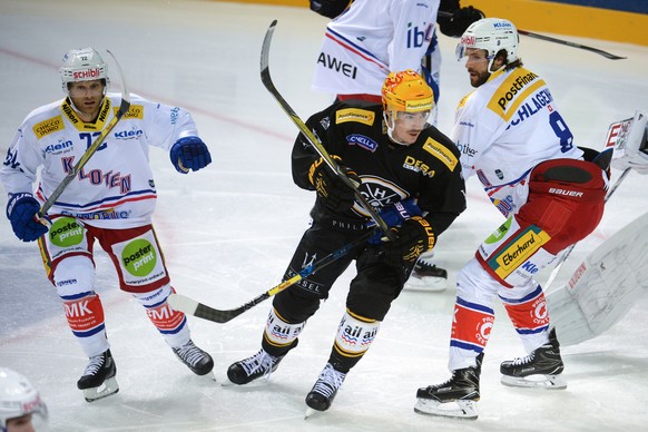 Kloten&#039;s player Patrick von Gunten, Luganoâs player Dario Buergler and Kloten&#039;s player Roman Schlagenhauf, from left, fight for the puck during the National League game of the Swiss Champi ...