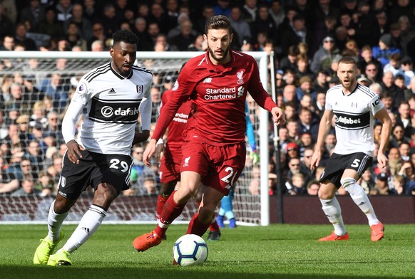 epa07444956 Fulham&#039;s Andre-Frank Zambo Anguissa (L) vies for the ball against Liverpool&#039;s Adam Lallana (C) during the English Premier League soccer match between Fulham FC and Liverpool FC a ...