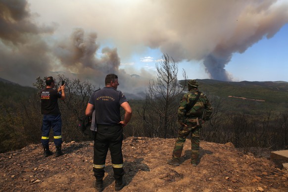epa10811630 Firefighters watch the smoke from a wildfire at Dadia forest, in Alexandroupolis, Thrace, northern Greece, 21 August 2023. The wildfire that broke out early on 19 August in a forest in the ...
