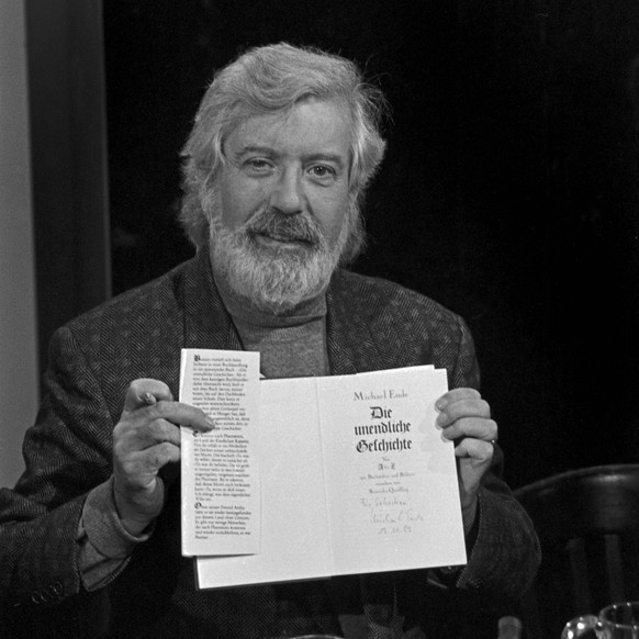 Der deutsche Schriftsteller Michael Ende mit seinem Buch Die unendliche Geschichte , Deutschland 1990er Jahre. German author Michael Ende with his book The Neverending Story , Germany 1990s. UnitedArc ...