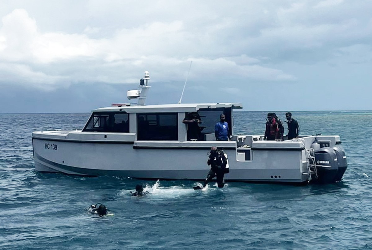 epa12976487 A handout photo made available by the Maldives President's Media Division shows divers conduct search and recovery operations for the remaining bodies of Italian tourists in the water ...
