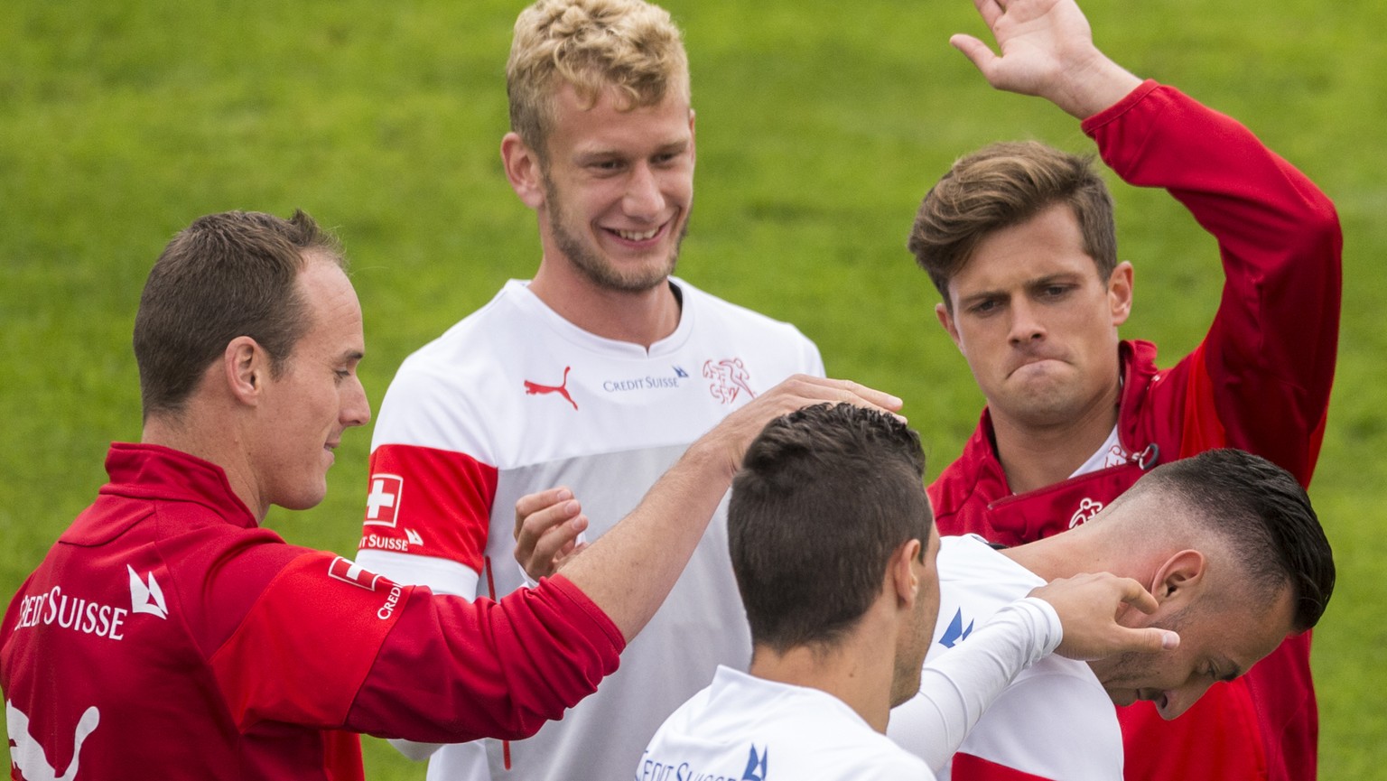 Von links: Steve Von Bergen, Fabian Lustenberger und Valentin Stocker geben einen Klaps auf den Hinterkopf von Josip Drmic waehrend dem Training der Schweizer Fussball Nationalmannschaft in Jona, am D ...