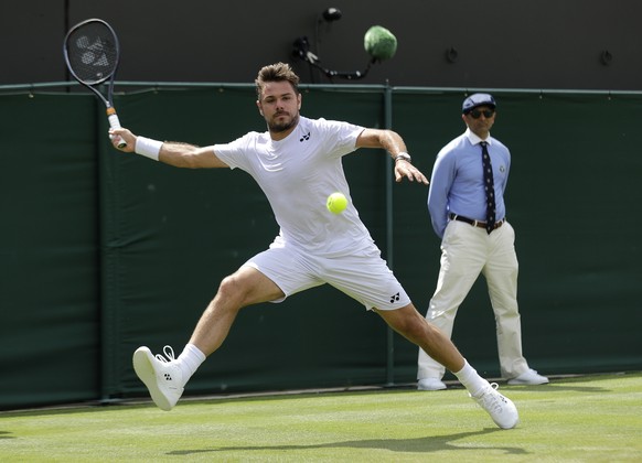 Switzerland's Stan Wawrinka returns in his Men's singles match against United States' Reilly Opelka during day three of the Wimbledon Tennis Championships in London, Wednesday, July 3, ...