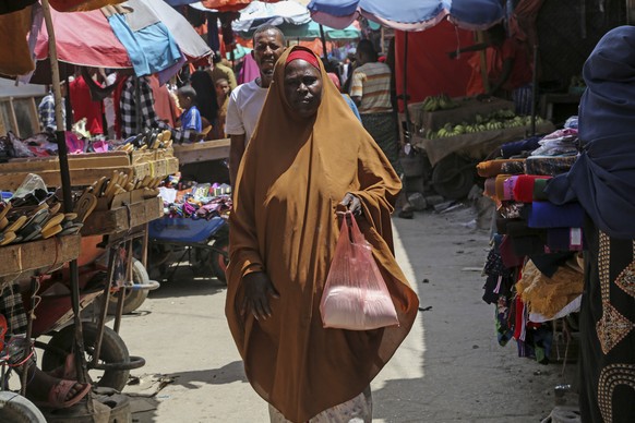 Halimo Hersi, 42, walks home after buying wheat flour from a trader in the Hamar-Weyne market in the capital Mogadishu, Somalia Thursday, May 26, 2022. Families across Africa are paying about 45% more ...