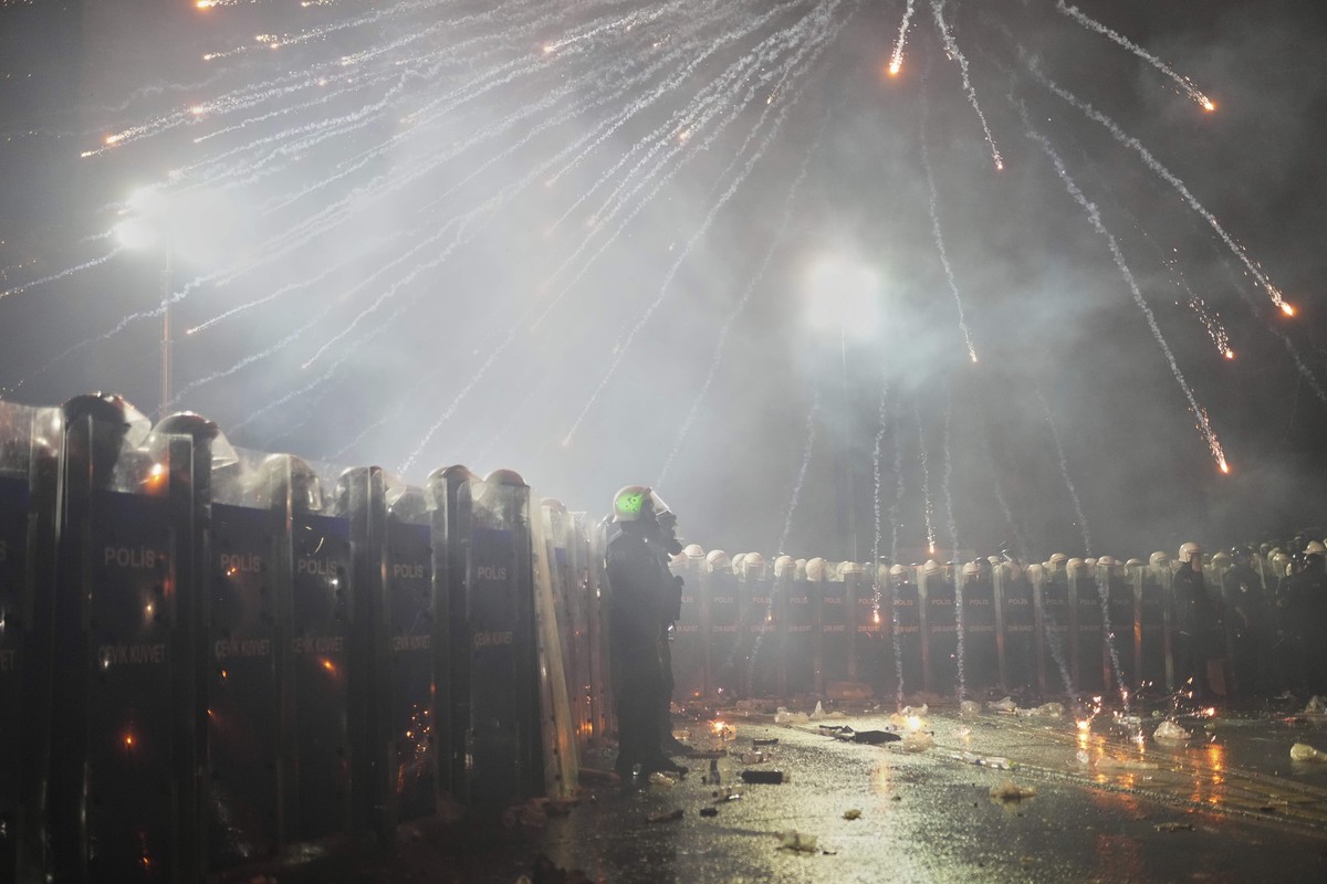 Fireworks thrown by protesters explode over riot police during a protest after Istanbul's Mayor Ekrem Imamoglu was arrested and sent to prison, in Istanbul, Turkey, Sunday, March 23, 2025. (AP Ph ...