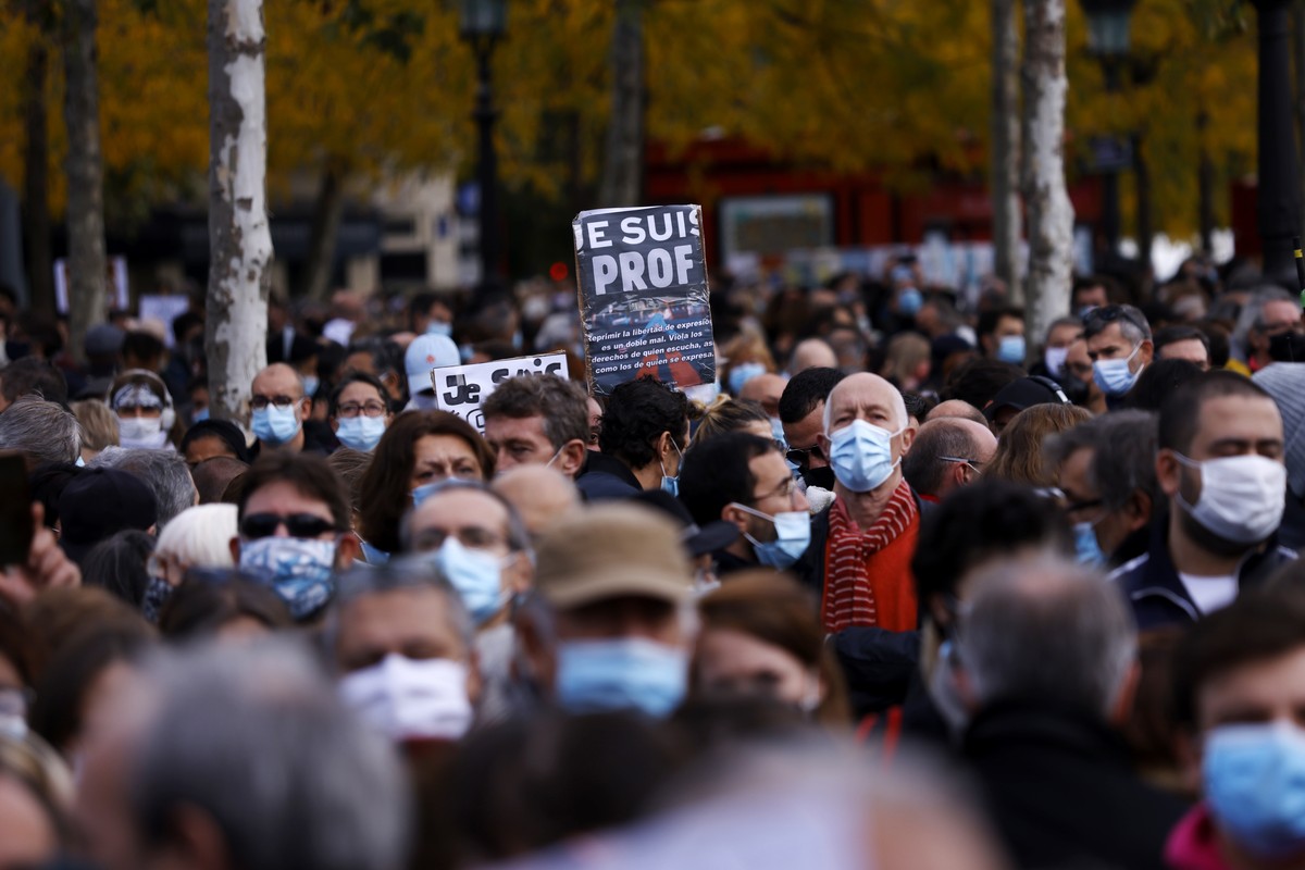 epa08755247 A person holds a sign reading " I am a teacher" as people gather at the Place de la Republique for a demonstration against terrorism and to pay their respect after French teacher ...