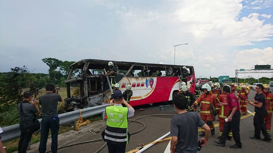 epa05431494 A handout photo released by the Taoyuan City Fire Department show police and firemen inspect the scene of a tourist coach fire near the Taoyuan Internatinal Airport in Taoyuan County outsi ...