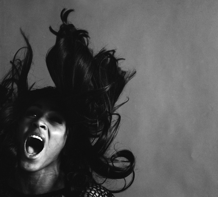 Studio portrait of American rock singer Tina Turner, wearing a dark crocheted mini-dress, singing while her long dark hair flies around her face, New York, New York, November 25, 1969. (Photo by Jack  ...