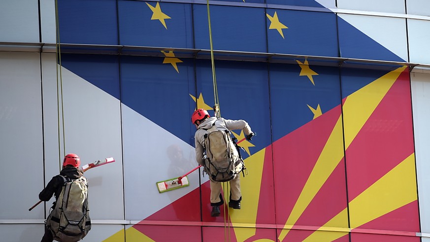 Arbeiter putzen die Fassade am EU-Büro in Skopje: Aufgemalt sind die Flaggen der EU und Nordmazedoniens.