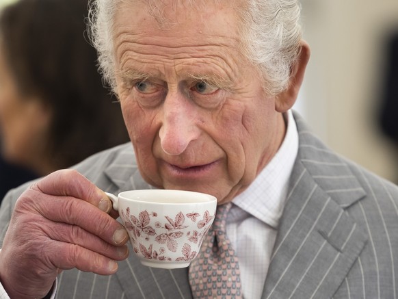 FILE - Britain&#039;s King Charles III sips tea, during a visit to Talbot Yard, in Yorkersgate, Malton, North Yorkshire, England, Wednesday April 5, 2023. (James Glossop/Pool Photo via AP, File)