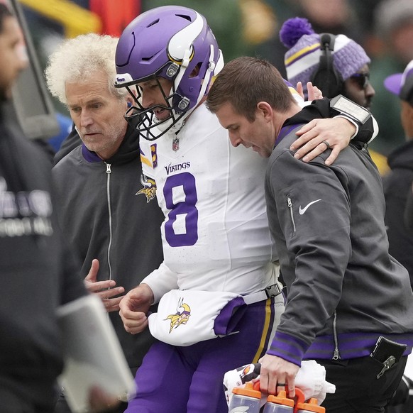 Minnesota Vikings quarterback Kirk Cousins (8) is helped off the field after going down with an injury in the fourth quarter of an NFL game against the Green Bay Packers, Sunday, Oct. 29, 2023, in Gre ...