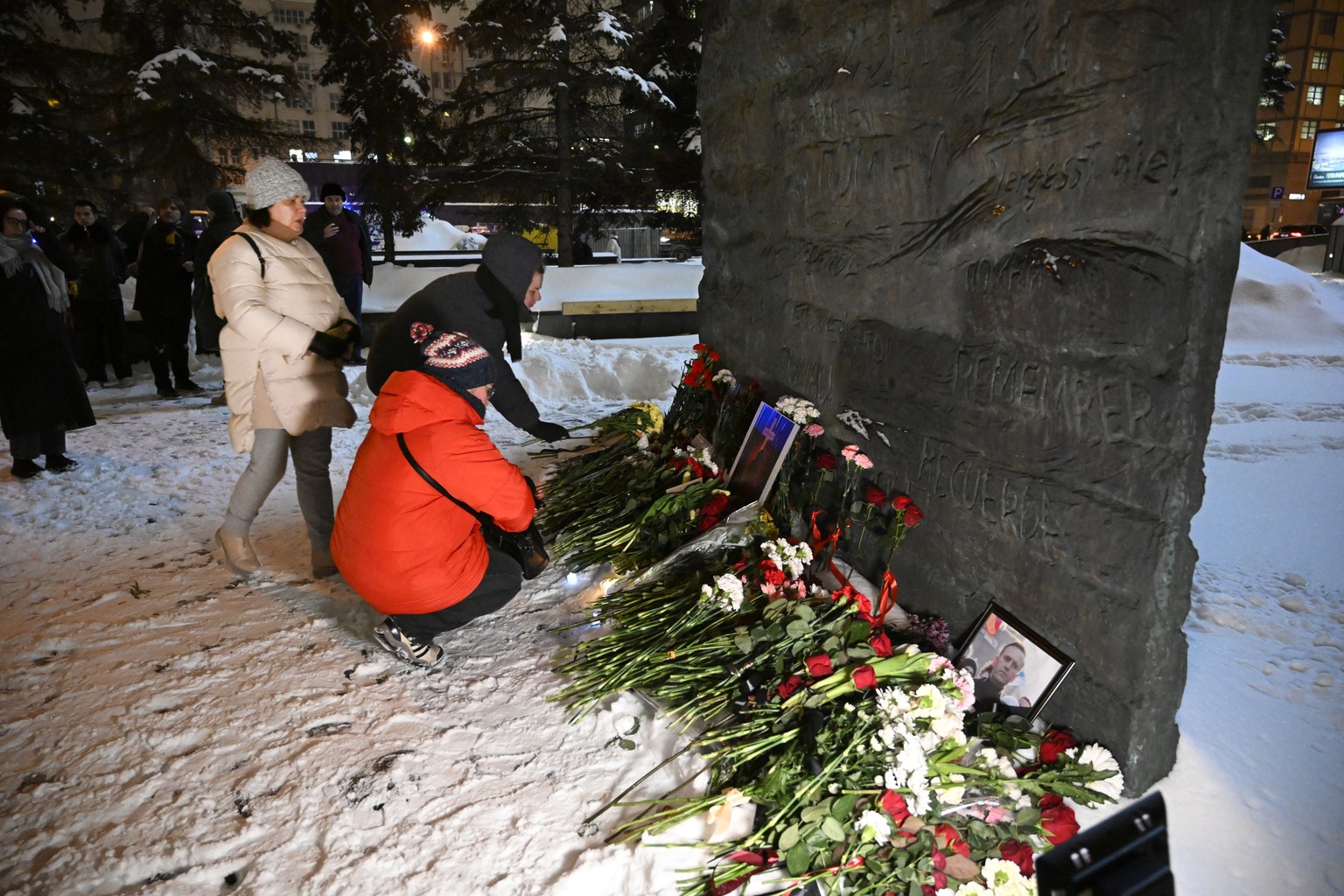 People gather to lay flowers paying their last respect to Alexei Navalny at the at the Wall of Sorrow memorial to victims of political repression in Moscow, Russia, Friday, Feb. 16, 2024. Russian auth ...