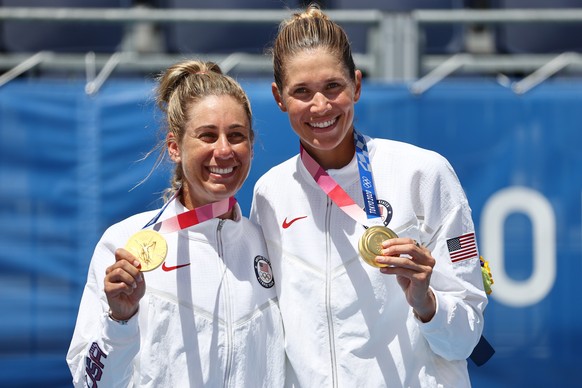 epa09399337 Alix Klineman (R) and April Ross (L) of the US celebrate after winning the Beach Volleyball Women&#039;s Gold Medal match between the US and Australia of the Tokyo 2020 Olympic Games at th ...