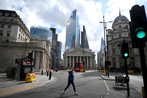 epa08421642 A woman passes the Bank of England in the financial district in the City of London, Britain, 14 May 2020. British Chancellor Sunak said it is very likely that the UK is facing a 'significa ...