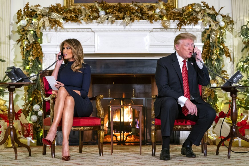 epa07247879 US President Donald J. Trump (R) and First Lady Melania (L) speak with children who are calling the NORAD (North American Aerospace Defense Command) Santa tracker in the State Dining Room  ...