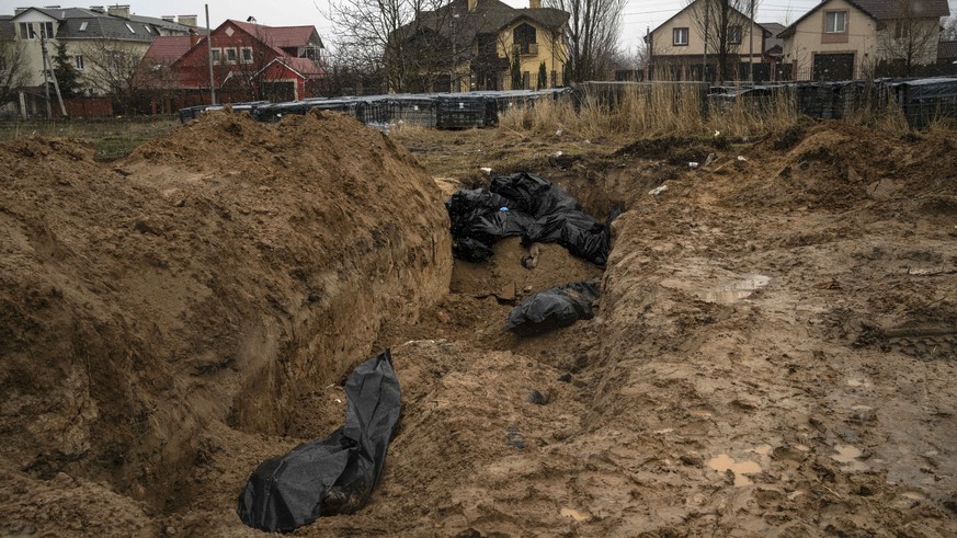 FILE - Bodies lie scattered in a mass grave in Bucha, Ukraine, on the outskirts of Kyiv, Sunday, April 3, 2022. Ukrainian troops found brutalized bodies and widespread destruction in the suburbs of Ky ...