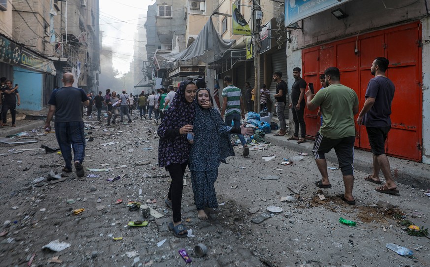 epa10919045 Two girls cry as they walk from the site of an Israeli rocket attack in Al- Shati refugee camp in the west of Gaza City on, 14 October 2023. The Israeli Defense Force (IDF) on 13 October c ...