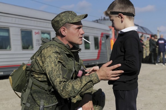 A Russian recruit speaks to his son prior to take a train at a railway station in Prudboi, Volgograd region of Russia, Thursday, Sept. 29, 2022. Russian President Vladimir Putin has ordered a partial mobilization of reservists to beef up his forces in Ukraine. (AP Photo)