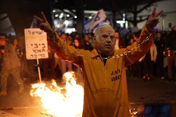 epa11239616 A demonstrator dressed in a convict uniform and wearing a Benjamin Netanyahu mask takes part in a protest against Israeli Prime Minister Netanyahu&#039;s government and to demand the relea ...
