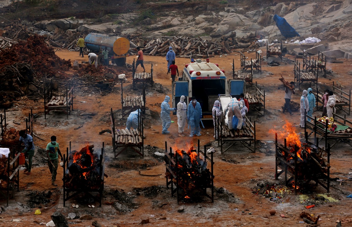 epaselect epa09175681 Funeral pyres for COVID-19 victims burn during a mass funeral at a makeshift cremation ground at Giddenahalli in the outskirts of Bangalore, India, 03 May 2021. India recorded a  ...