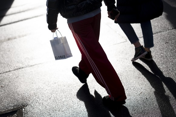 Menschen mit laufen mit einer Einkaufstasche des Luxus-Warenhaus Globus an der Bahnhofstrasse am Dienstag, 13. Januar 2026 in Zuerich. Die Kette streicht rund einen Drittel der Stellen im Hauptsitz un ...