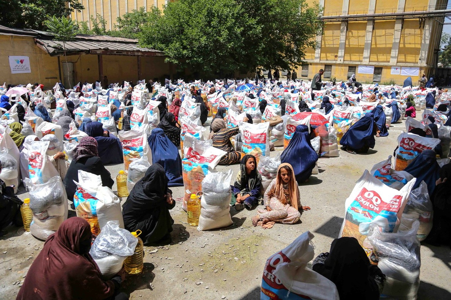 epa10783113 Afghans receive food rations in Kabul, Afghanistan, 03 August 2023. In partnership with the Ministry of Immigrants and Returnees Affairs, the &#039;Women for Afghan Women&#039; organizatio ...