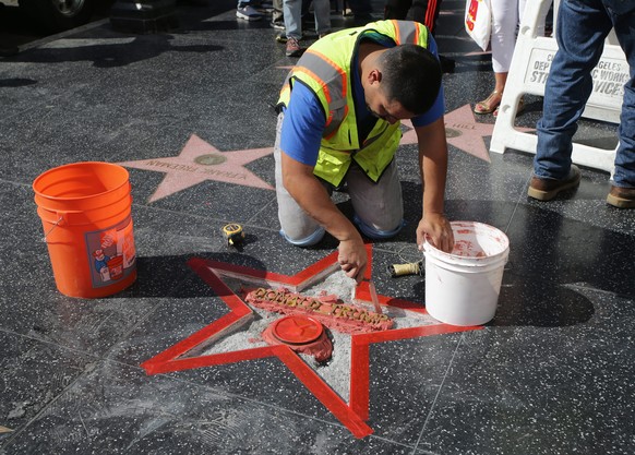 epa05604606 A worker from Top End Constructors repairs US Republican Presidential candidate Donald Trump&#039;s star on the Hollywood Walk of Fame after it was destroyed in Hollywood, California, USA  ...