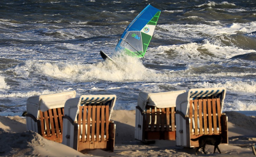 24.10.2018, Mecklenburg-Vorpommern, Warnemuende: Sturmtief &quot;Siglinde&quot; sorgt fuer eine aufgewuehlte Ostsee, ein Surfer nutzt den Wind fuer seinen Sport. Fuer eine Sturmflut an der Ostsee war  ...