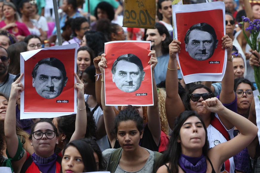 epa07057592 Brazilian women hold placards with the image of the candidate to Brazil presidency for the Liberal Social Party (PSL) Jair Bolsonaro (L) and Nazi dictator Adolf Hitler (R) during a demonst ...