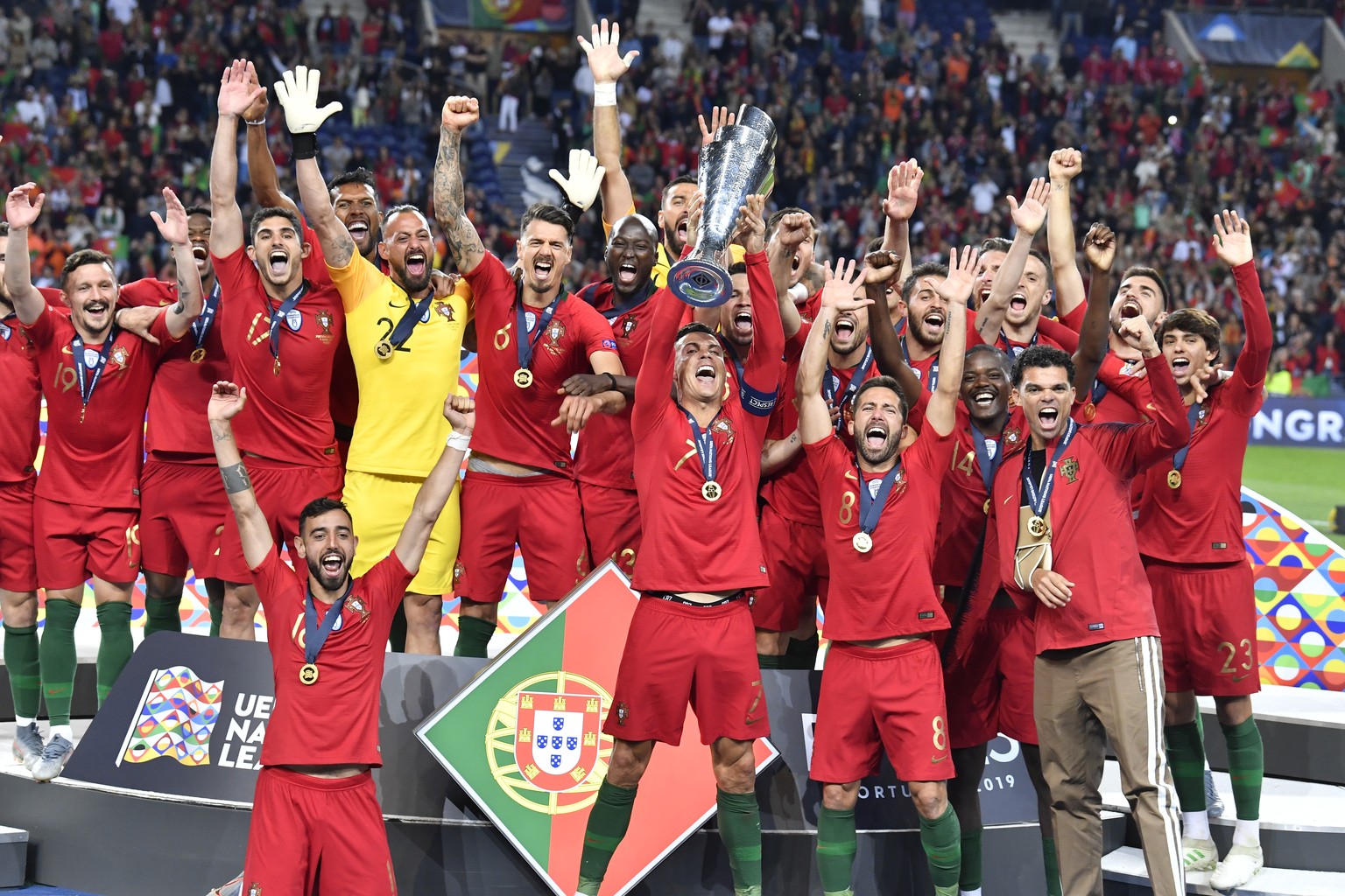 Portugal&#039;s Cristiano Ronaldo lifts up the trophy as he celebrates with players after winning the UEFA Nations League final soccer match between Portugal and Netherlands at the Dragao stadium in P ...