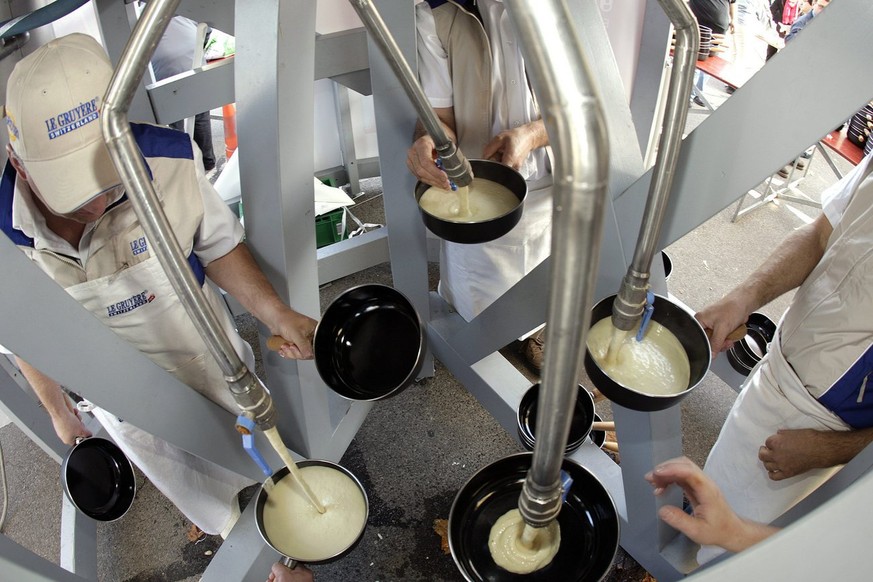 Des benevoles et des specialistes servent dans des caquelons la plus grande fondue au fromage du monde a 5&#039;000 personnes, ce samedi 25 octobre 2008 au Comptoir de Morges. Cette fondue en chiffres ...