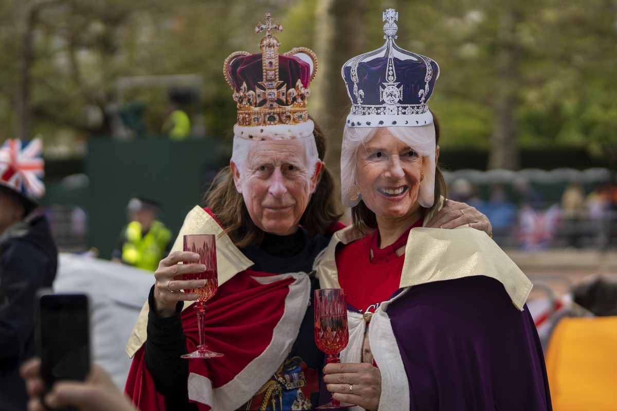 Royal fans pose for a photo along the King's Coronation route at The Mall in London, Friday, May 5, 2023. The Coronation of King Charles III will take place at Westminster Abbey on May 6. (AP Pho ...