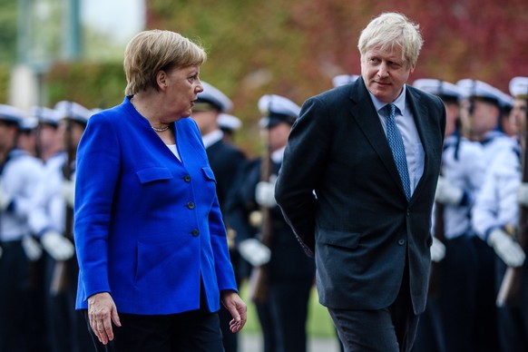 epa07784827 German Chancellor Angela Merkel (L) receives British Prime Minister Boris Johnson (R) with military honors at the Chancellery in Berlin, Germany, 21 August 2019. Prior to the G7 summit in  ...