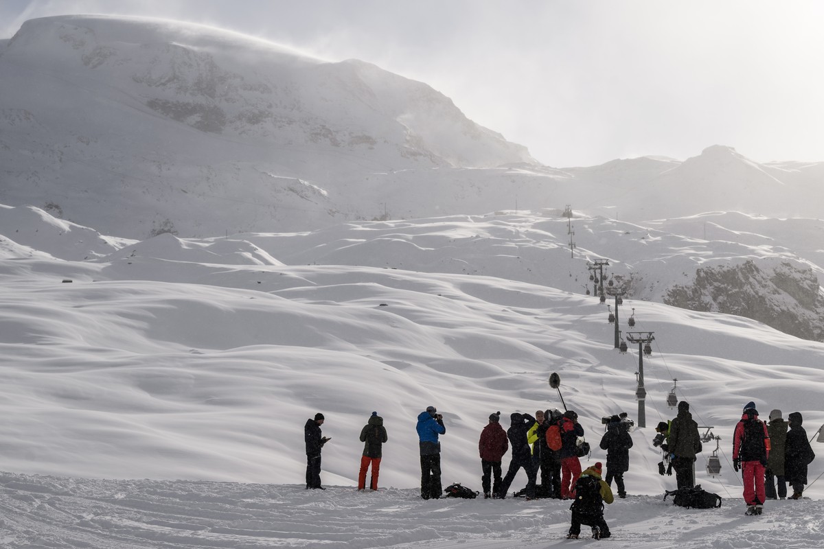 epa10969432 Journalists take pictures of the closed gondola as it reaches the finish area from 'Plan Maison' to 'Cime Bianche' area as they cancelled the men's Downhill race d ...