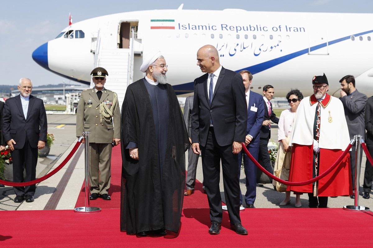 Swiss Federal President Alain Berset, right, and Iranian President Hassan Rohani, left, listen to the national anthems during Rohani's official visit to Switzerland at the Zurich airport in Klote ...