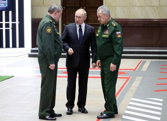 FILE Russian President Vladimir Putin, center, speaks with Chief of the General Staff Gen. Valery Gerasimov, left, and Russian Defense Minister Sergei Shoigu, after a meeting with senior military offi ...