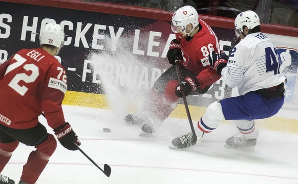 epa09967507 Switzerland&#039;s Dominik Egli and Janis Moser in action against Alexandre Texier of France (R) during the IIHF Ice Hockey World Championship group A preliminary round match between Switz ...