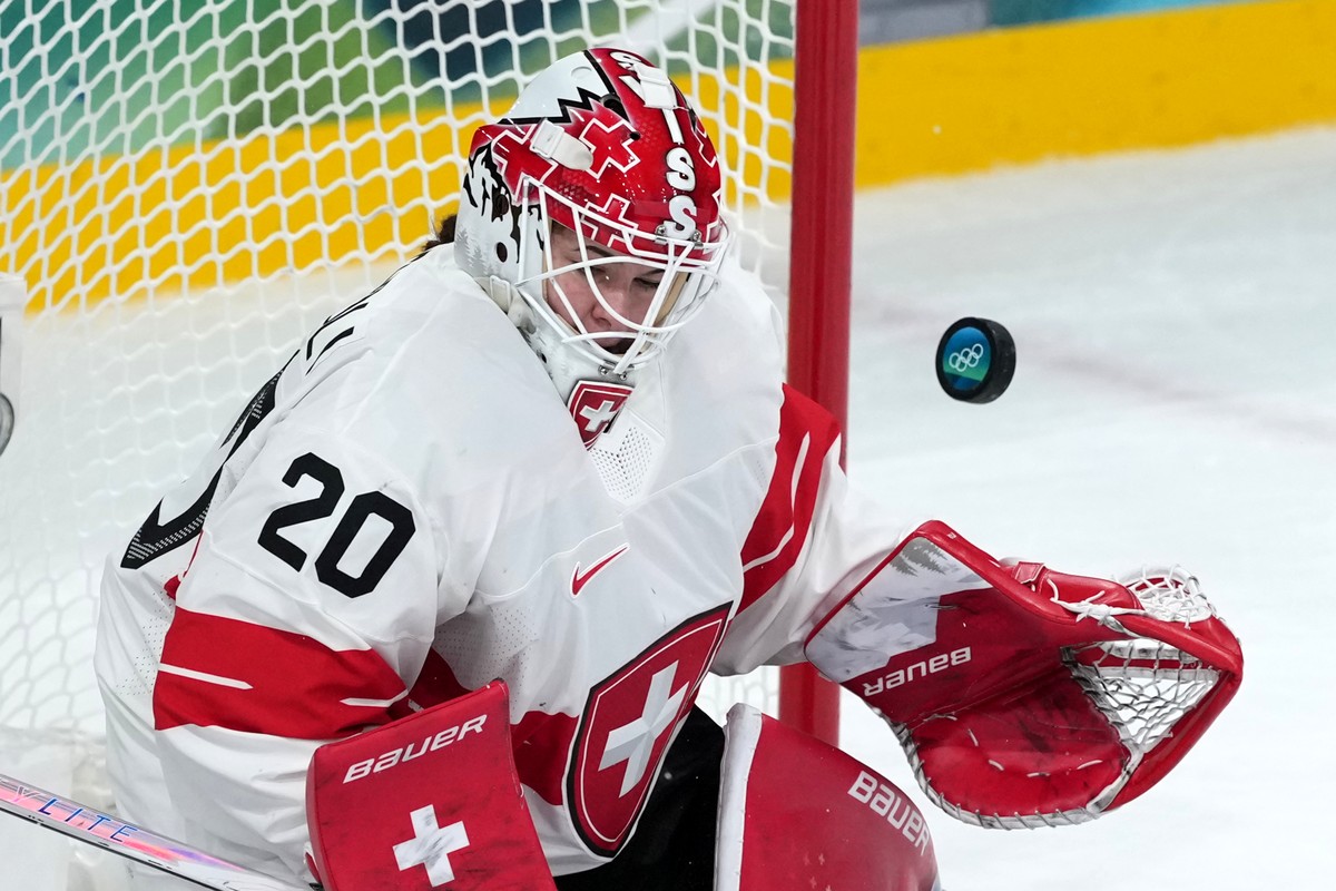 Switzerland goalkeeper Andrea Braendli (20) blocks a shot during the third period of a women's ice hockey quarterfinal match against Finland at the 2026 Winter Olympics, in Milan, Italy, Saturday ...
