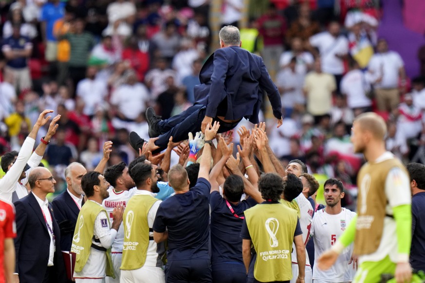 Players throw Iran&#039;s head coach Carlos Queiroz in air as they celebrate after their win in the World Cup group B soccer match between Wales and Iran, at the Ahmad Bin Ali Stadium in Al Rayyan, Qa ...