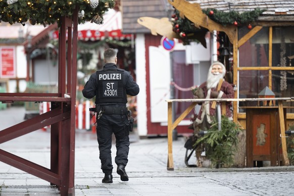 22.12.2024, Sachsen-Anhalt, Magdeburg: Ein Polizist geht �ber den gesperrten Weihnachtsmarkt. Am 20. Dezember 2024 ist auf dem Weihnachtsmarkt in Magdeburg ein Autofahrer in eine Menschengruppe gefahr ...