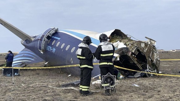 epa11792901 A handout photo made available by the press service of the Ministry for Emergency Situations of Kazakhstan shows emergency specialists working at the crash site of a passenger plane near A ...