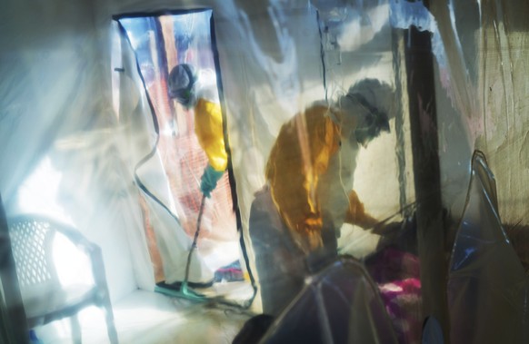 FILE - In this Saturday, July 13, 2019 file photo, health workers wearing protective suits tend to an Ebola victim kept in an isolation tent in Beni, Democratic Republic of Congo. On Wednesday, Oct. 1 ...